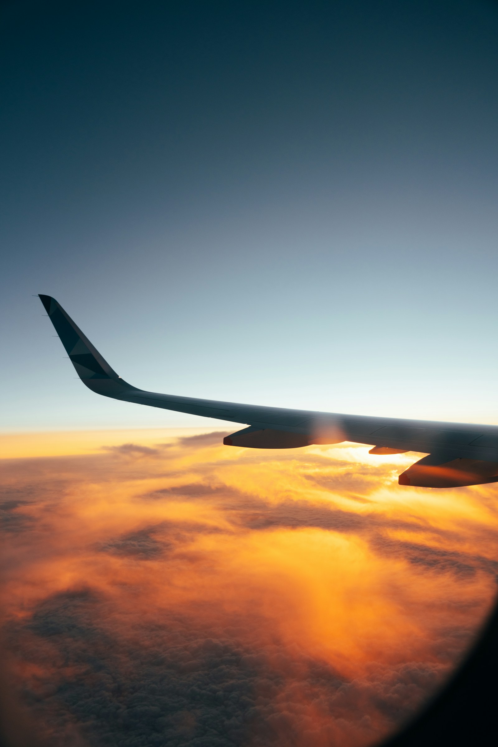 Aeroplane wing above sunlit clouds